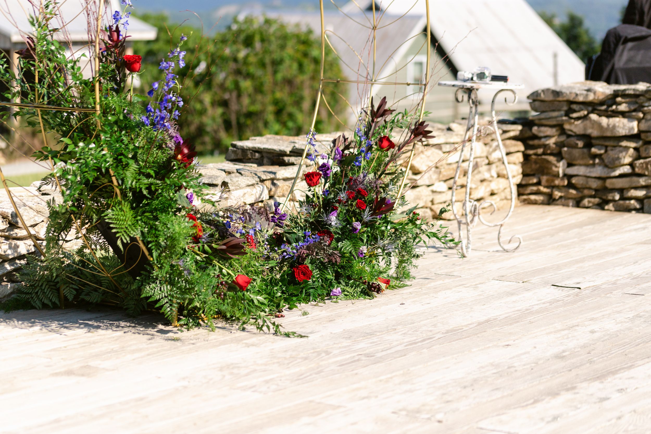 Colorful wildflower arrangement decorating a stone wall pathway.