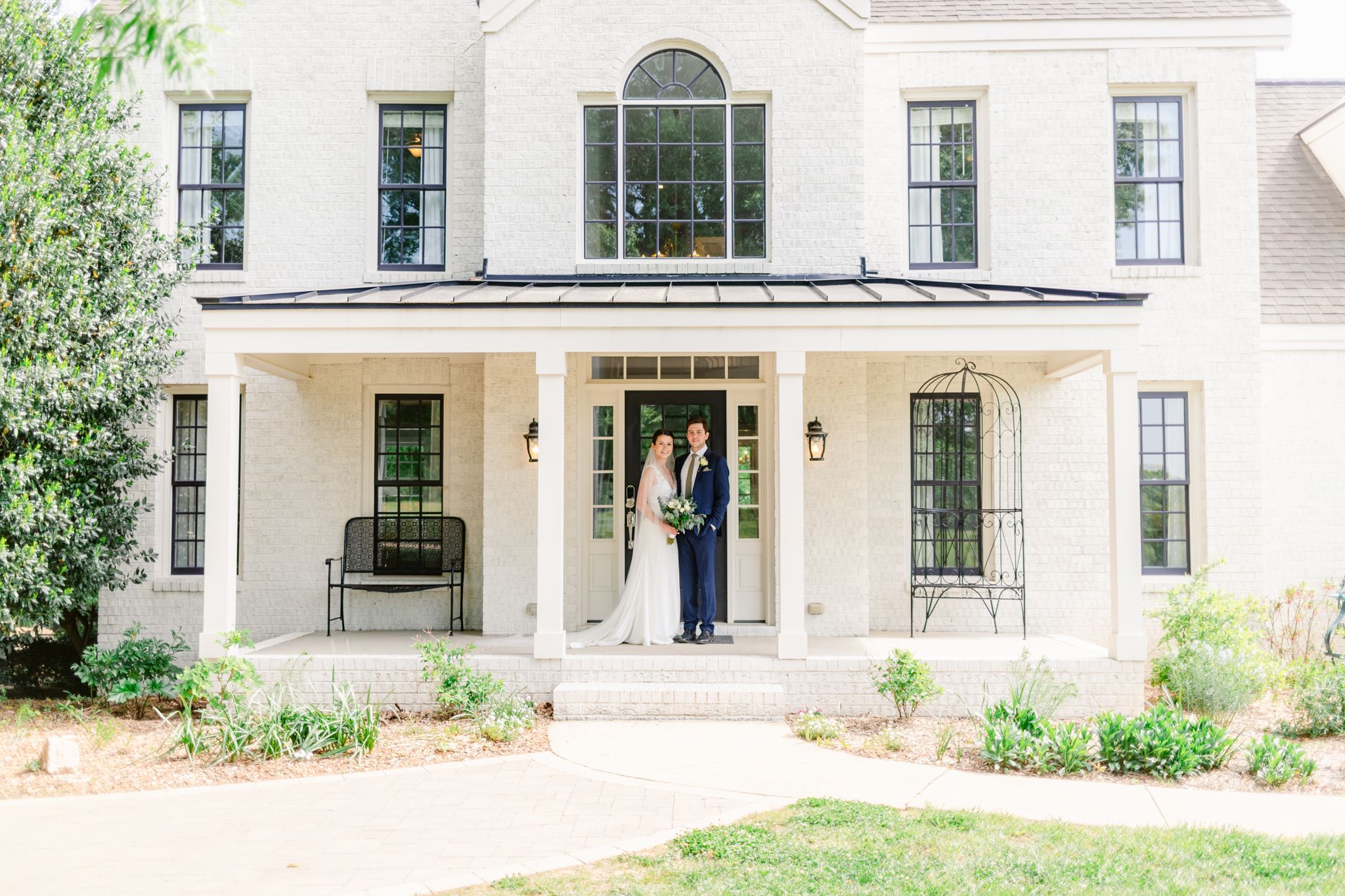 Exterior view of a white residential home with arched windows and traditional architectural details.