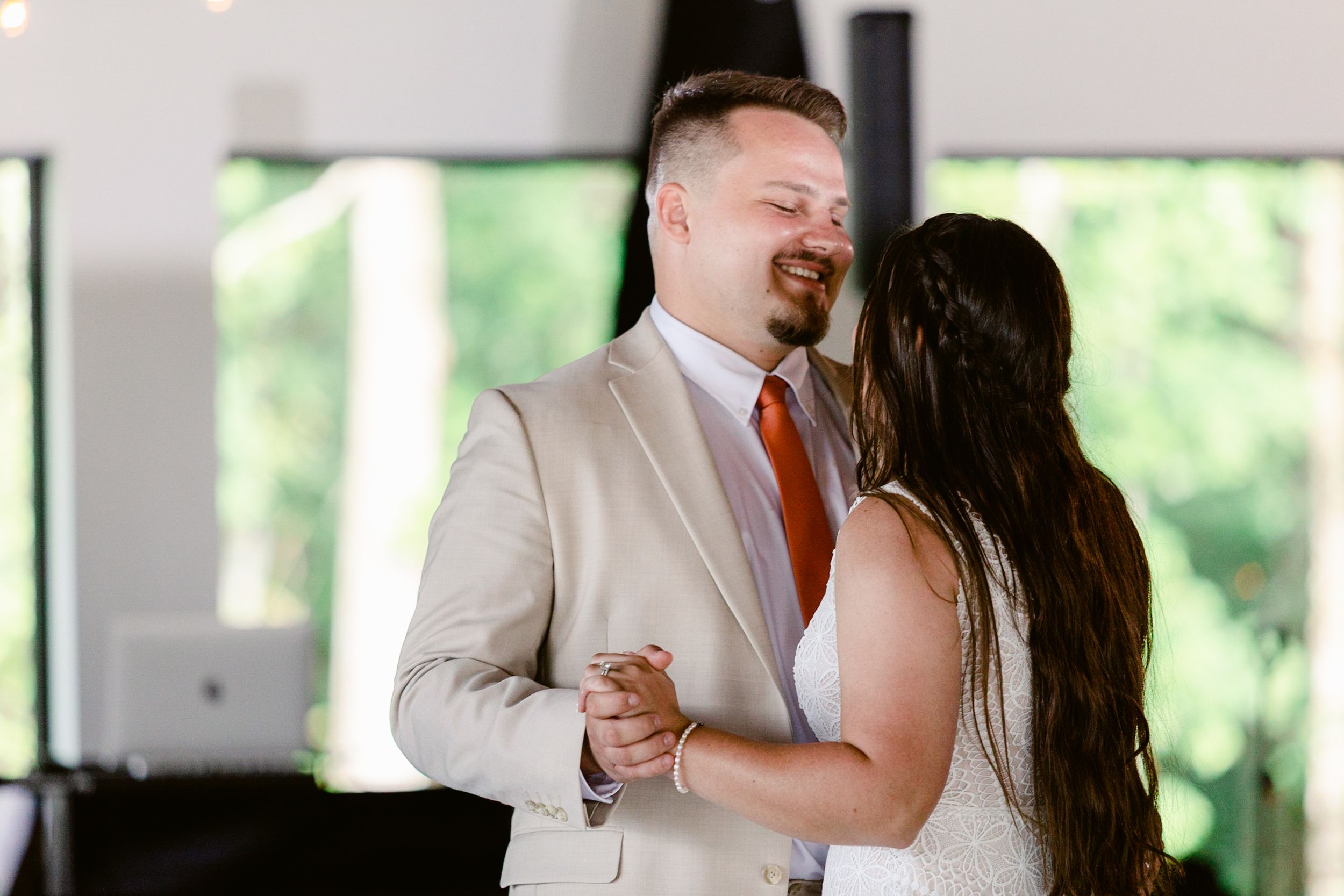 Wedding couple shares a tender dance moment together in an elegantly decorated reception venue.