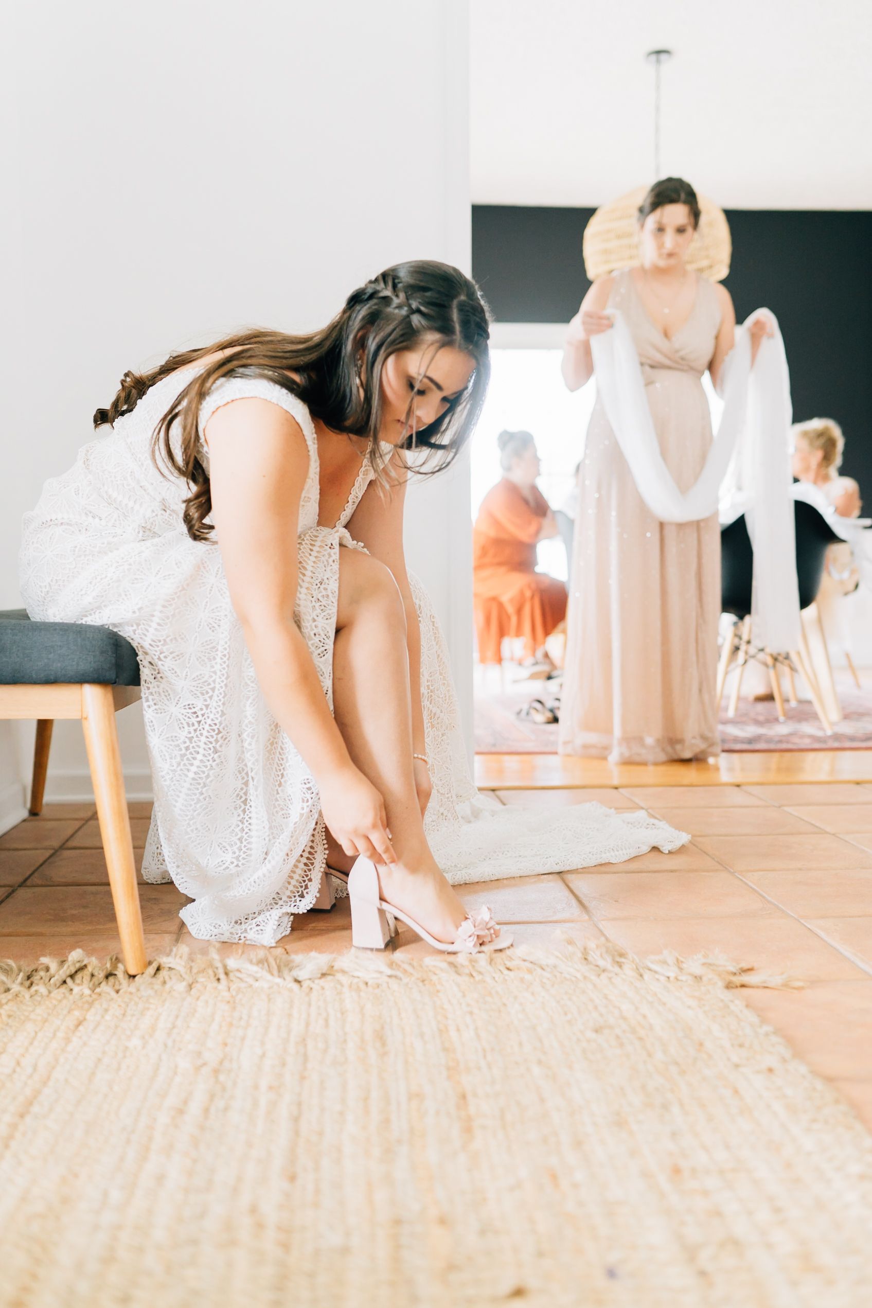 Series of shots showing sparkly wedding shoes being put on against a light wooden floor.