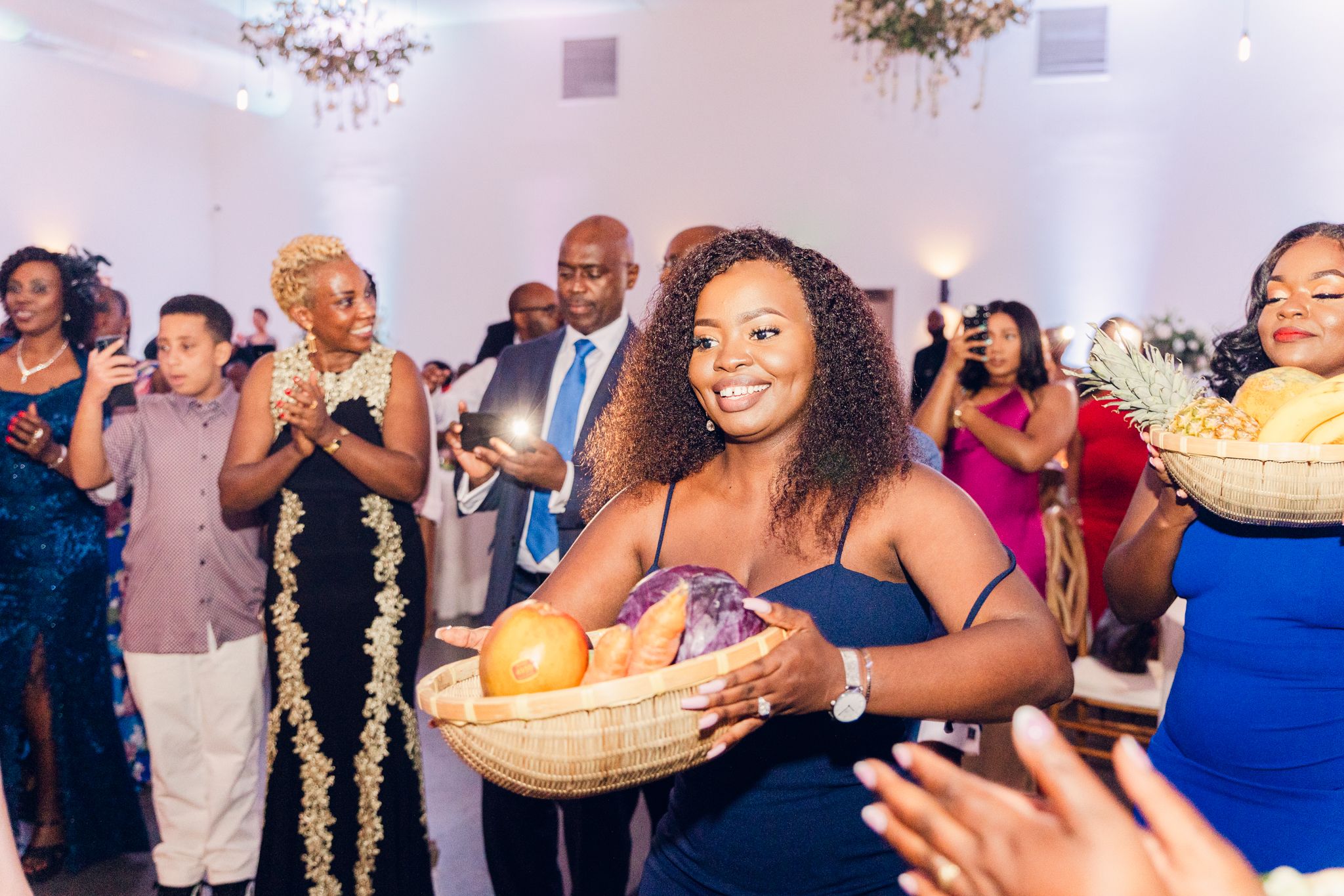 Wedding guests dancing and celebrating during a lively indoor reception party.