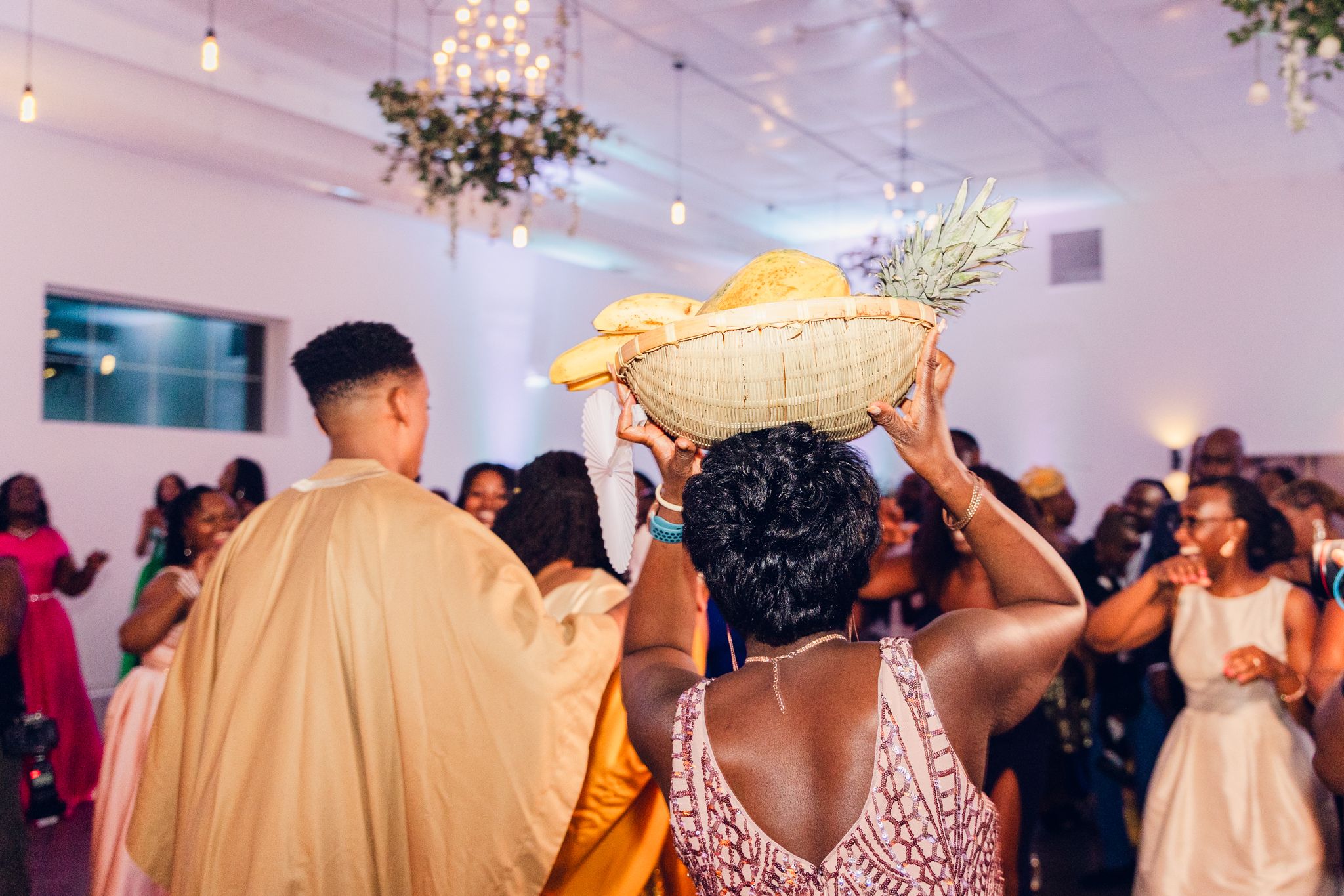 Wedding reception venue with chandelier and decorative foliage.