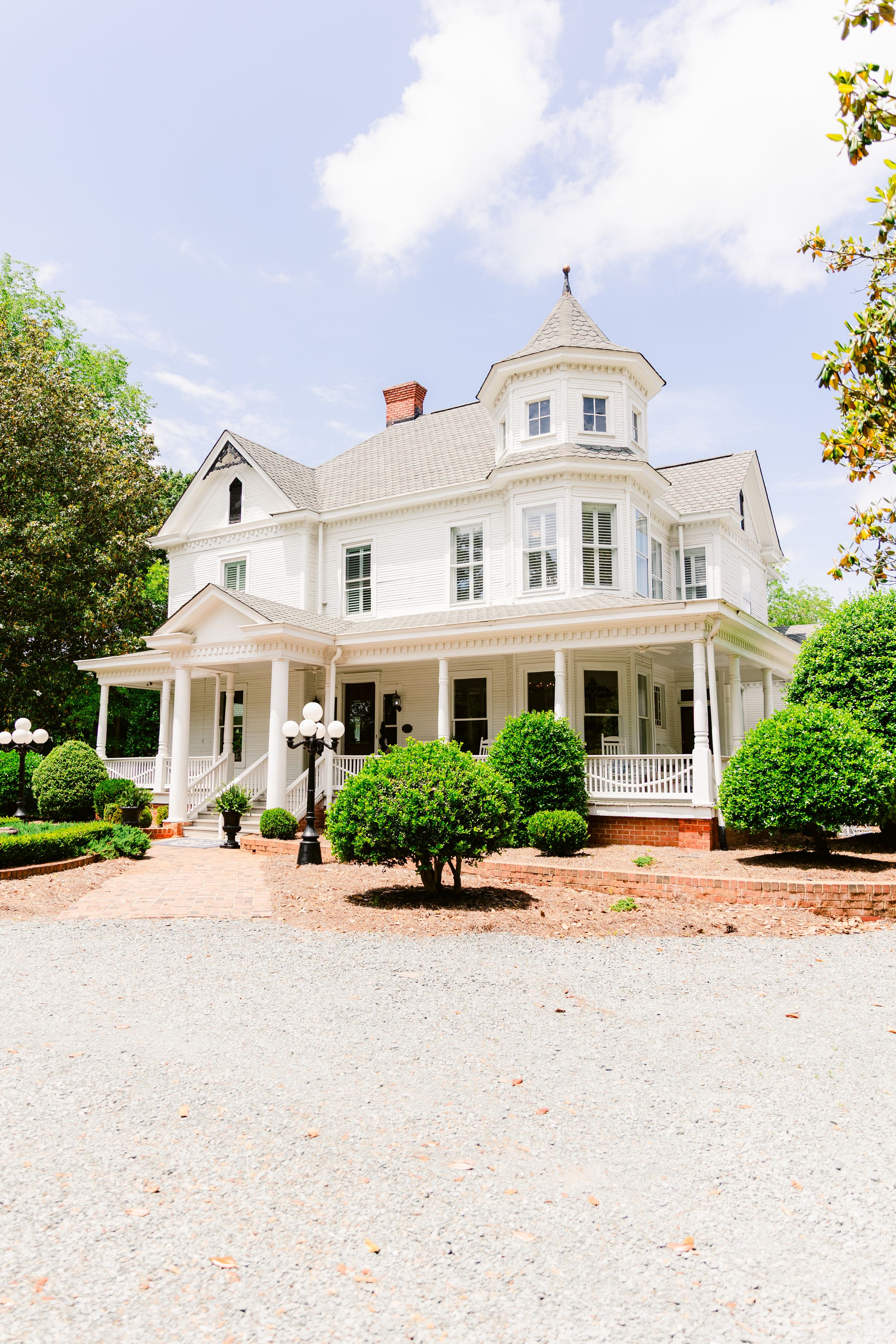 Classic white Southern mansion with wrap-around porch and cupola photographed from different angles.