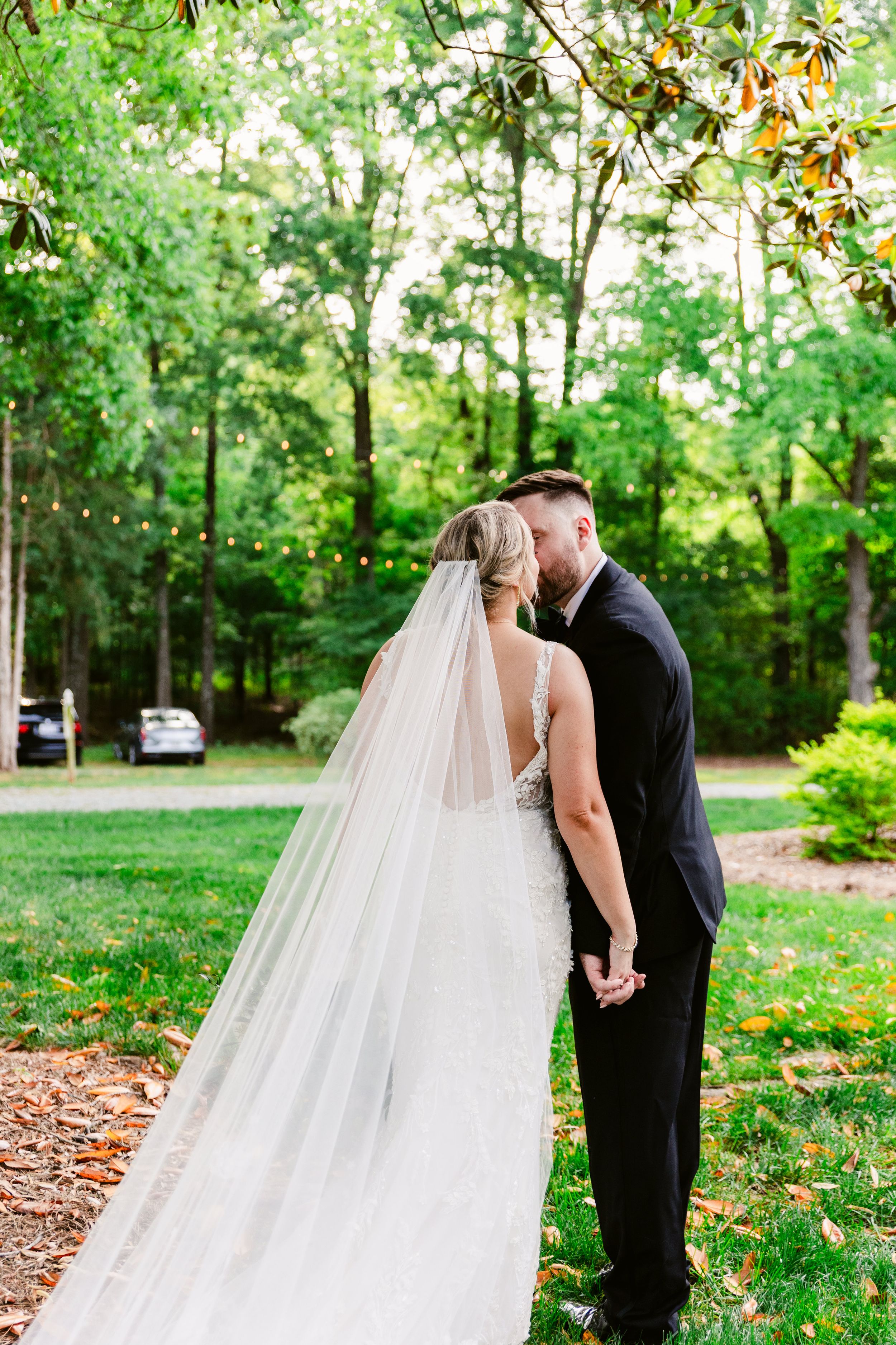 Romantic wedding couple shares tender moments in a lush green garden setting during their outdoor photo session.