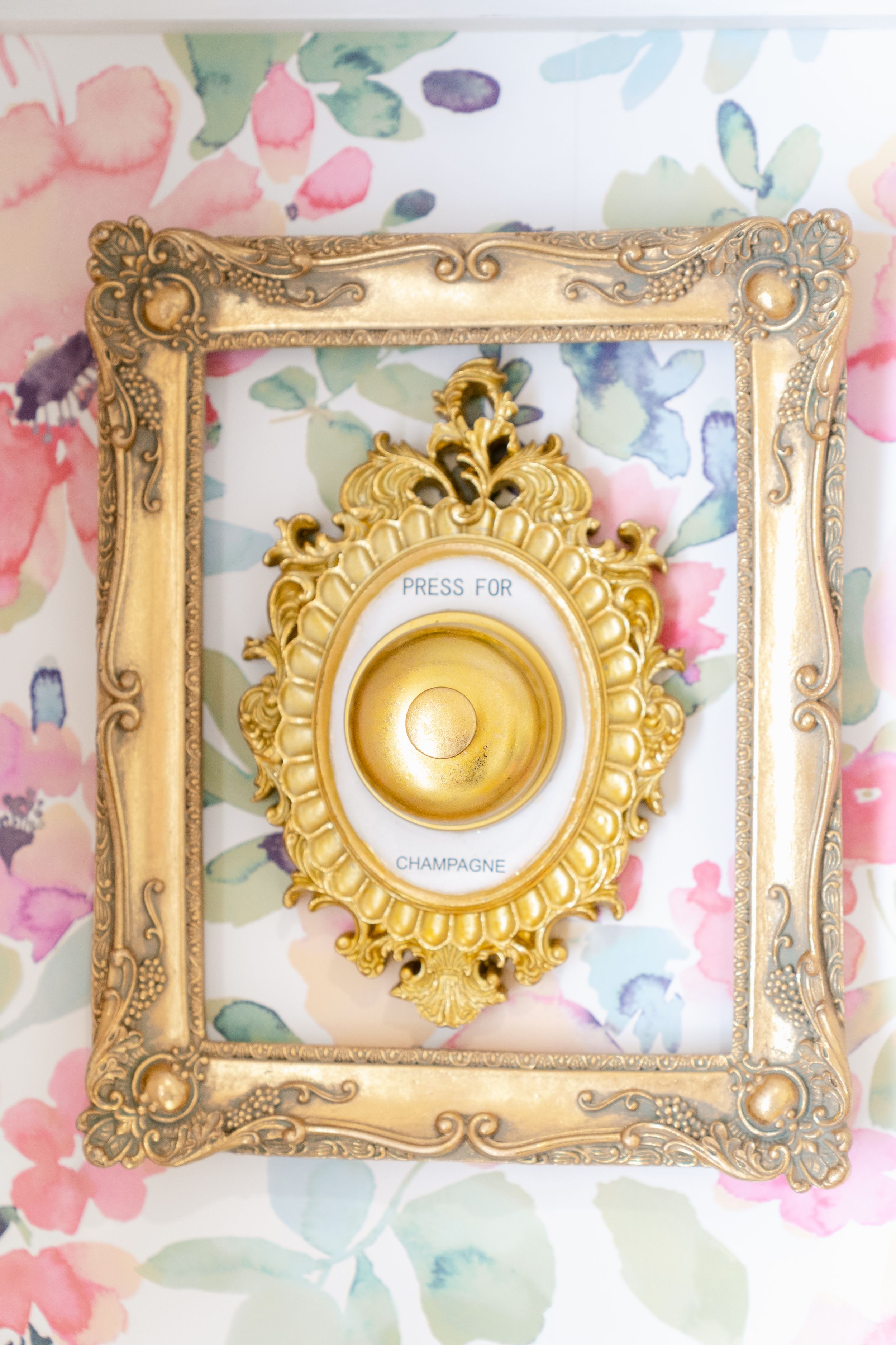 Ornate gold and cream vintage frame with decorative flourishes against floral watercolor background.
