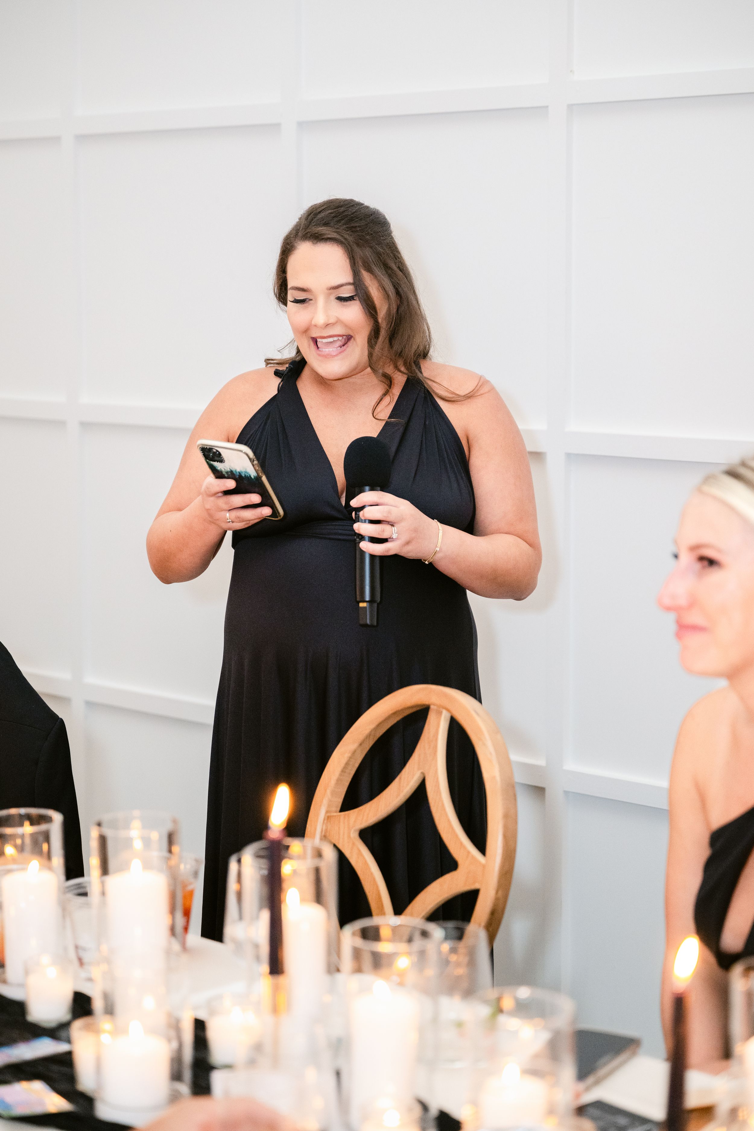 A table setting with glowing candles and elegant white decor at an upscale event.