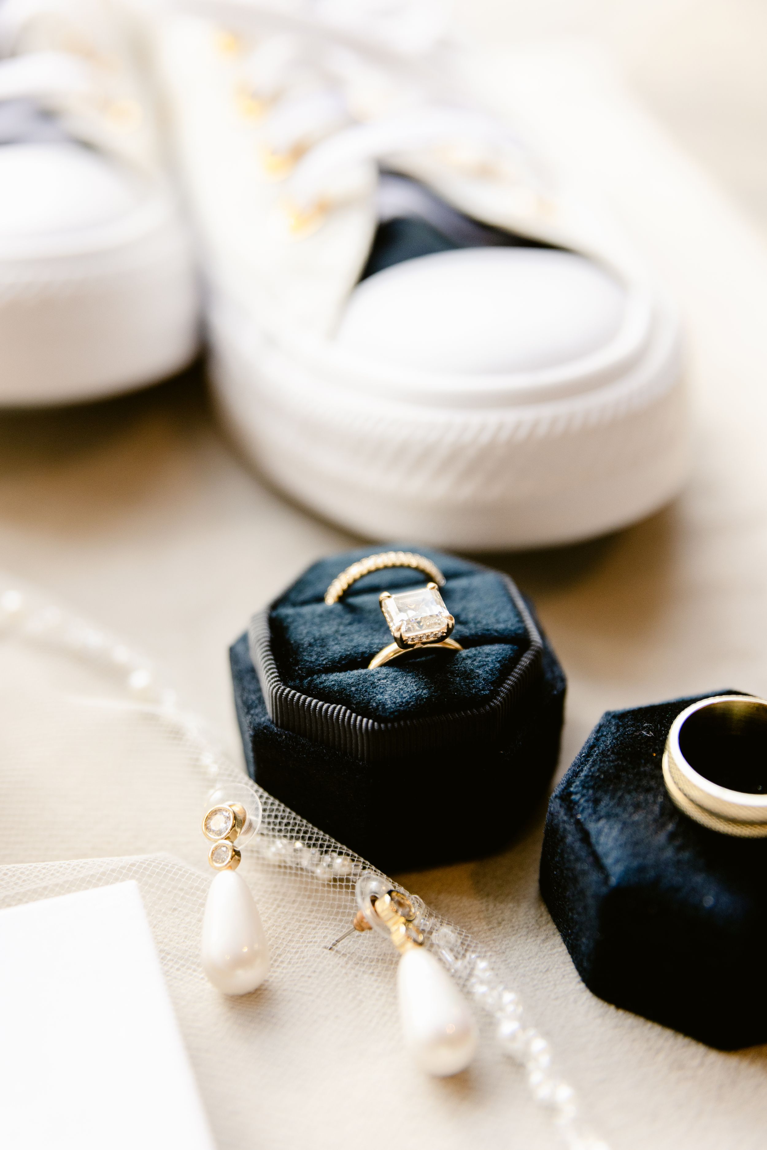 Close-up of an elegant diamond engagement ring nestled in a navy blue fabric holder.