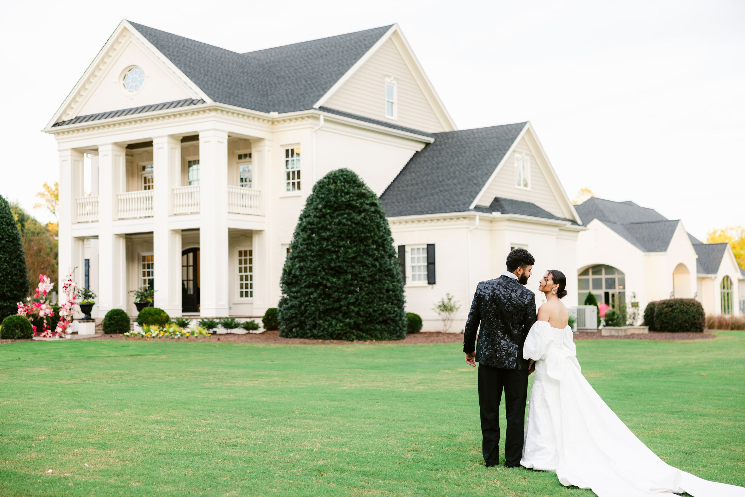 Classic white wedding venue with manicured lawn and colonial architecture.