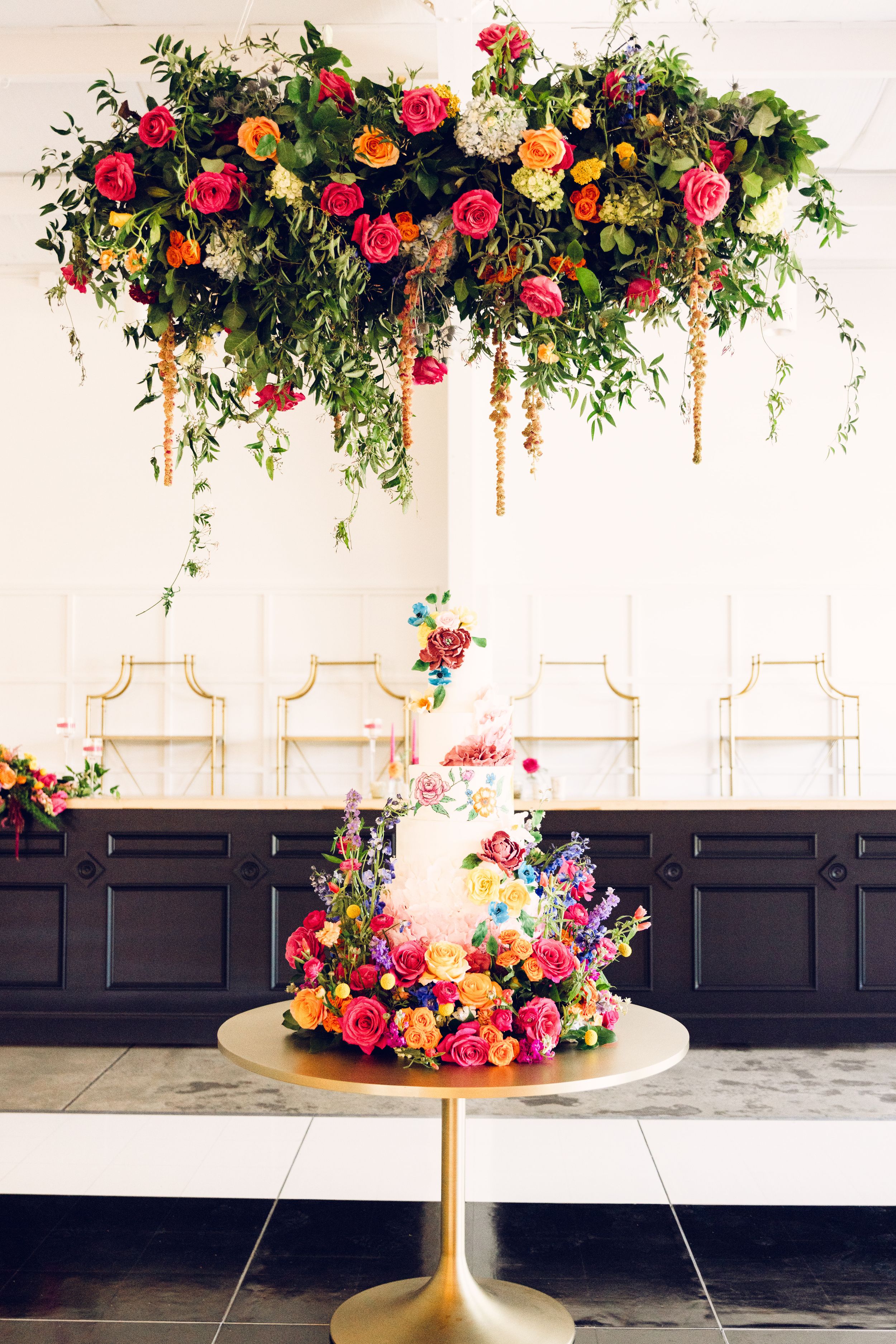 Stunning floral garland with pink, orange and white roses adorning a modern black and white interior space.