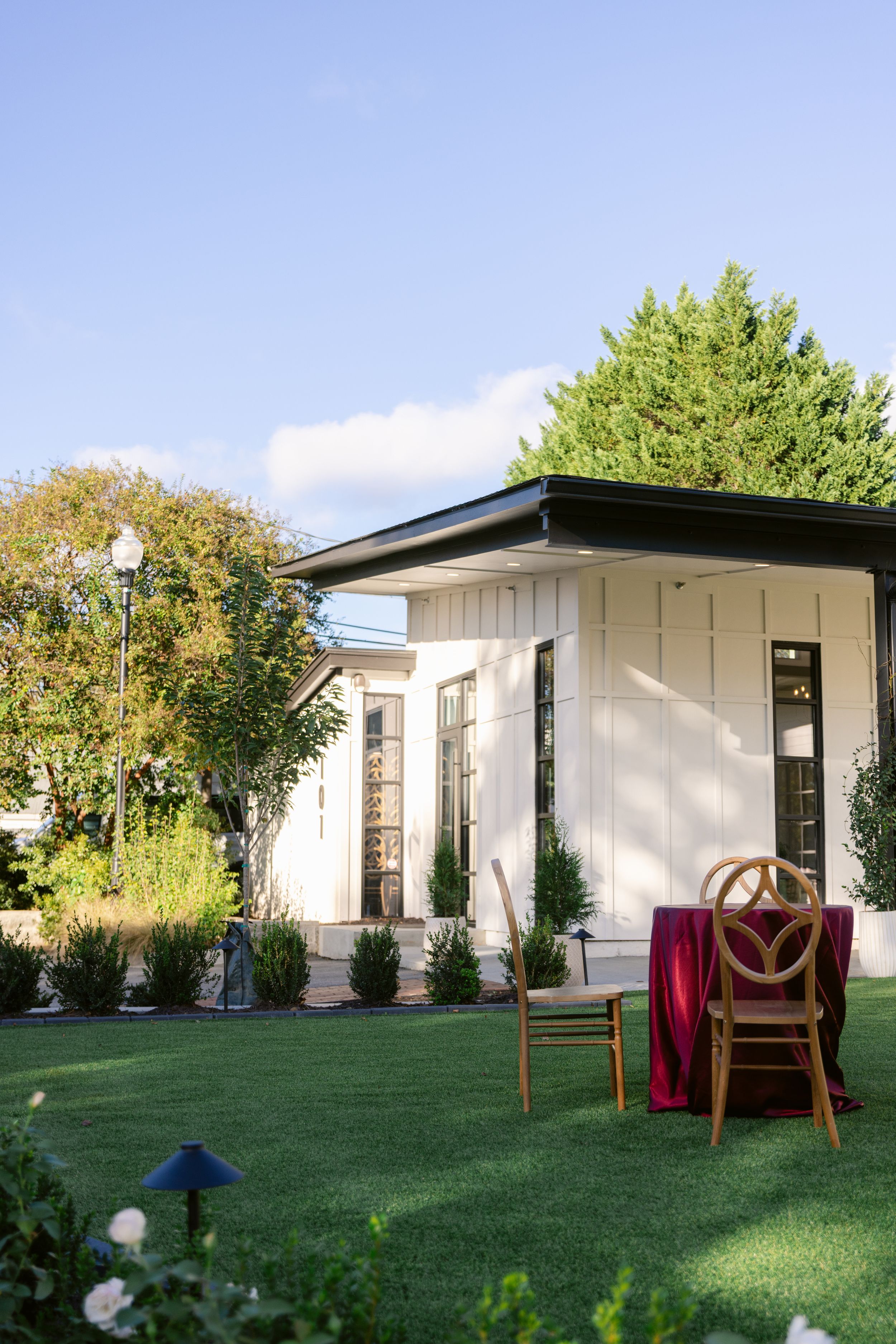 Modern white house with large windows and green lawn viewed from different angles in a backyard setting.